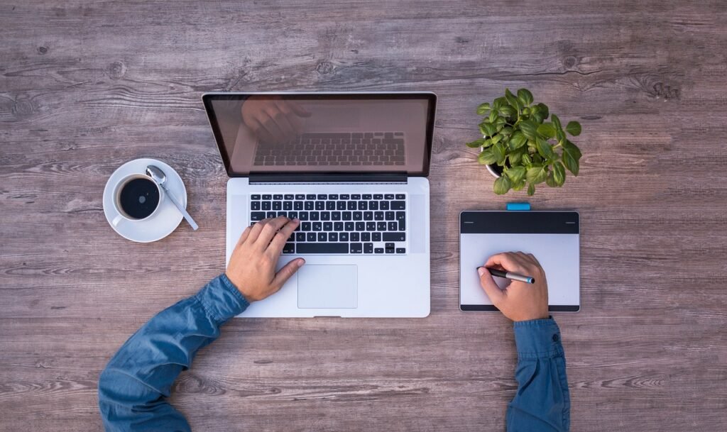 Graphic design workspace with laptop and graphics tablet