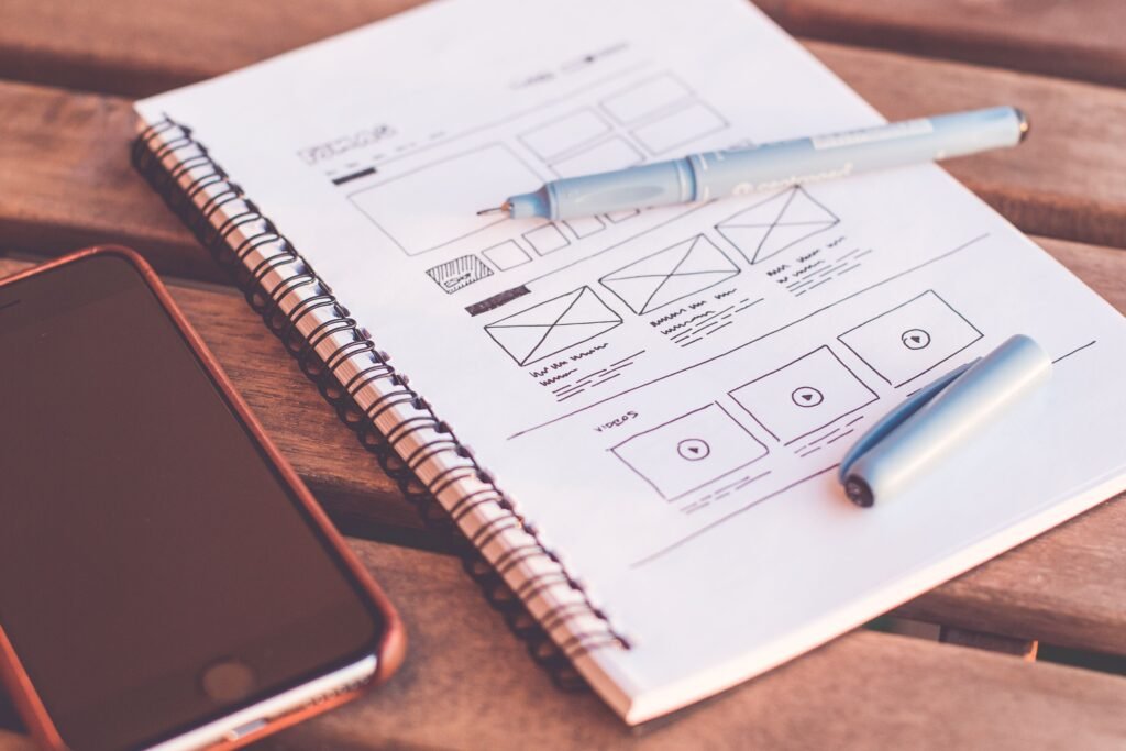 Wireframe sketches and smartphone for UI/UX design
