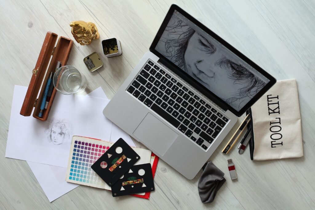 Creative design workspace with laptop and sketch supplies